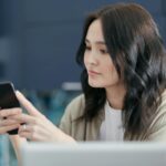 a woman holding black smartphone