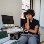 tired woman sitting in chair at work