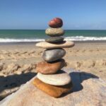 stack of colorful stones on sandy beach